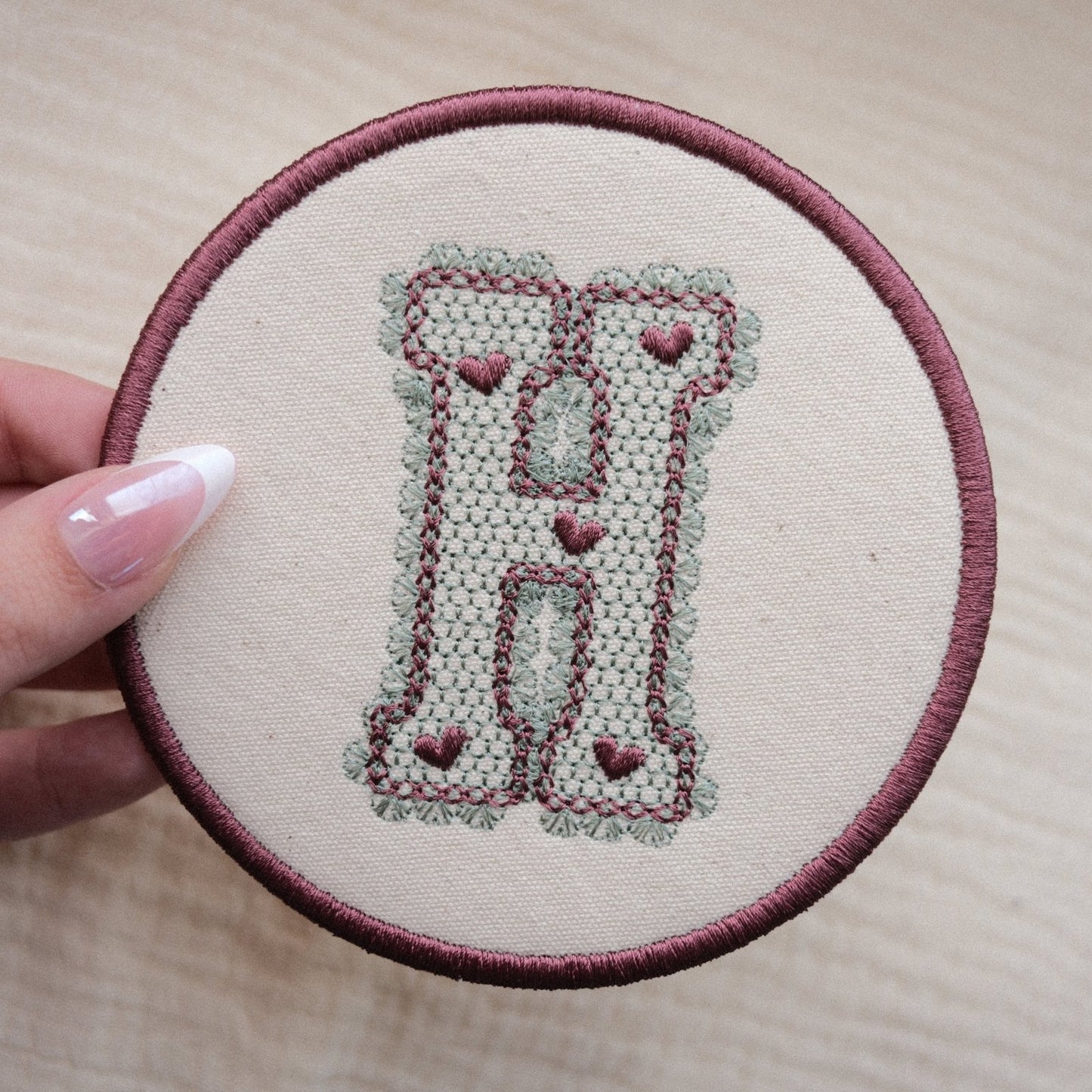 Personalised monogram coaster with embroidered lace effect letter H in sage green and plum thread colours