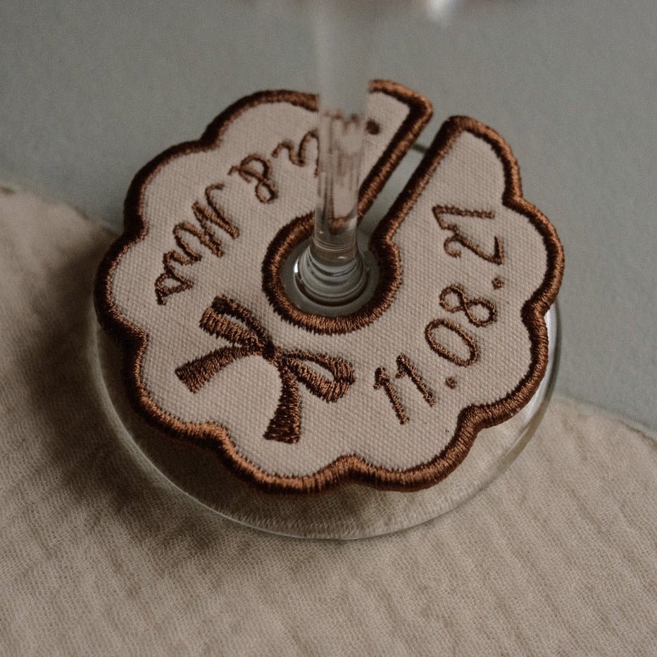 Neutral embroidered wine glass charm with personalised wedding names and date