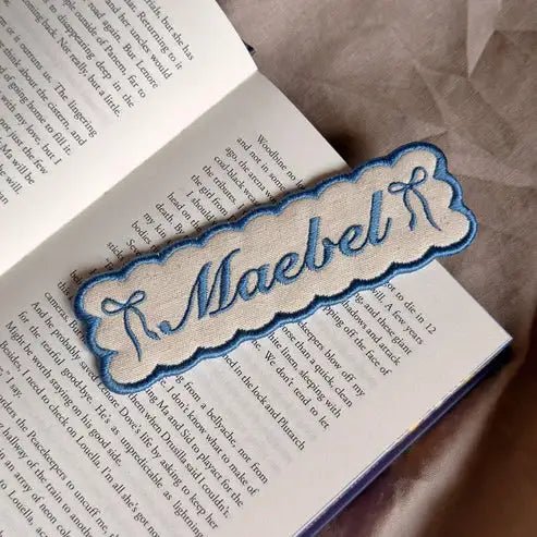Custom embroidered name bookmark in blue.