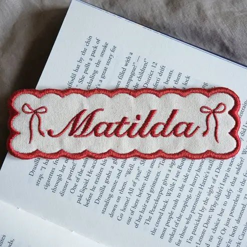 Custom embroidered name bookmark in red.