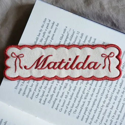 Custom embroidered name bookmark in red.