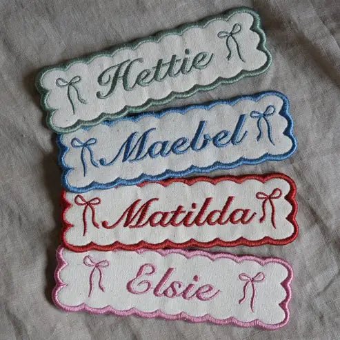 Four bookmarks, custom embroidered with names on a linen background.